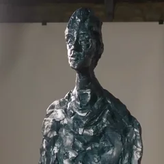 A portrait head in clay on a modelling stand